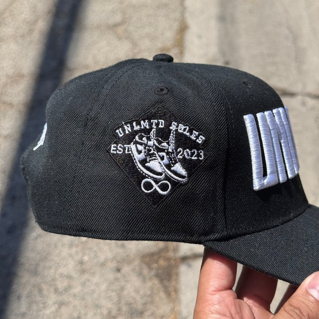 Left side profile of black cap with embroidered “UNLMTD SOLES” patch 
