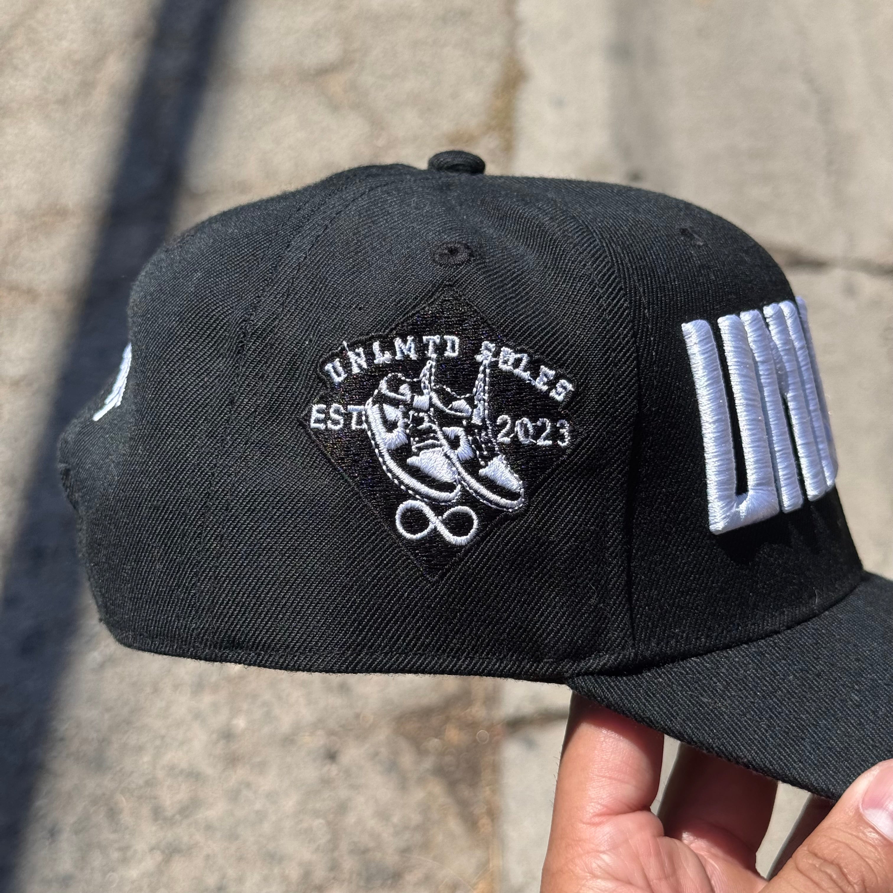 Left side profile of black cap with embroidered “UNLMTD SOLES” patch 