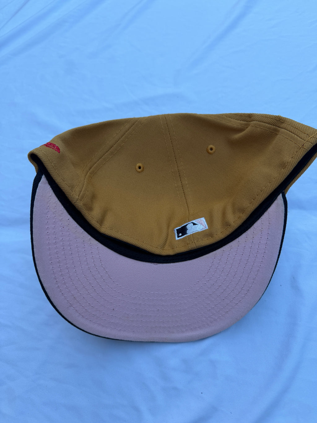 Bottom view of hat, light pink under brim