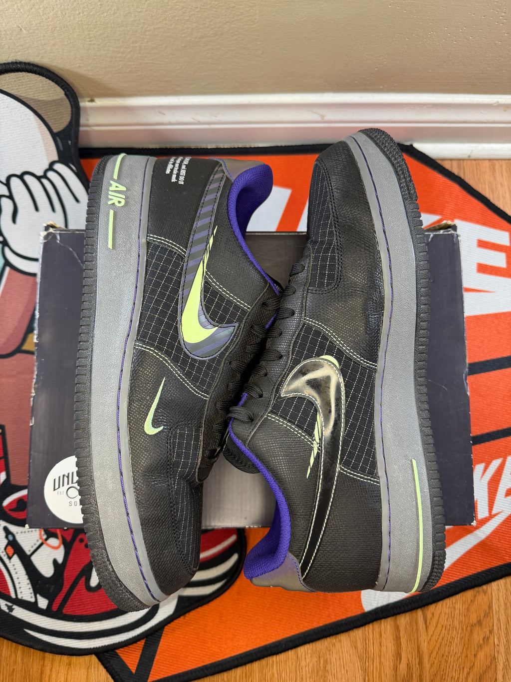 Side view of shoes. 3 Nike swooshes. Green and Purple 