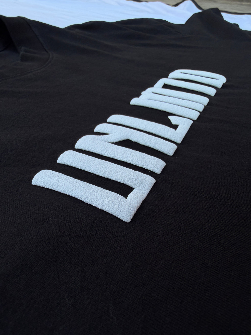 Close up of white puff print letters on black shirt 