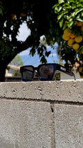 Black shades with white ULMTD letters on right temple