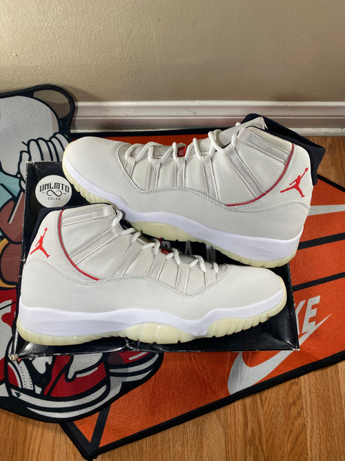 Jordan 11 Retro Platinum Tint cream sneakers with red accents 