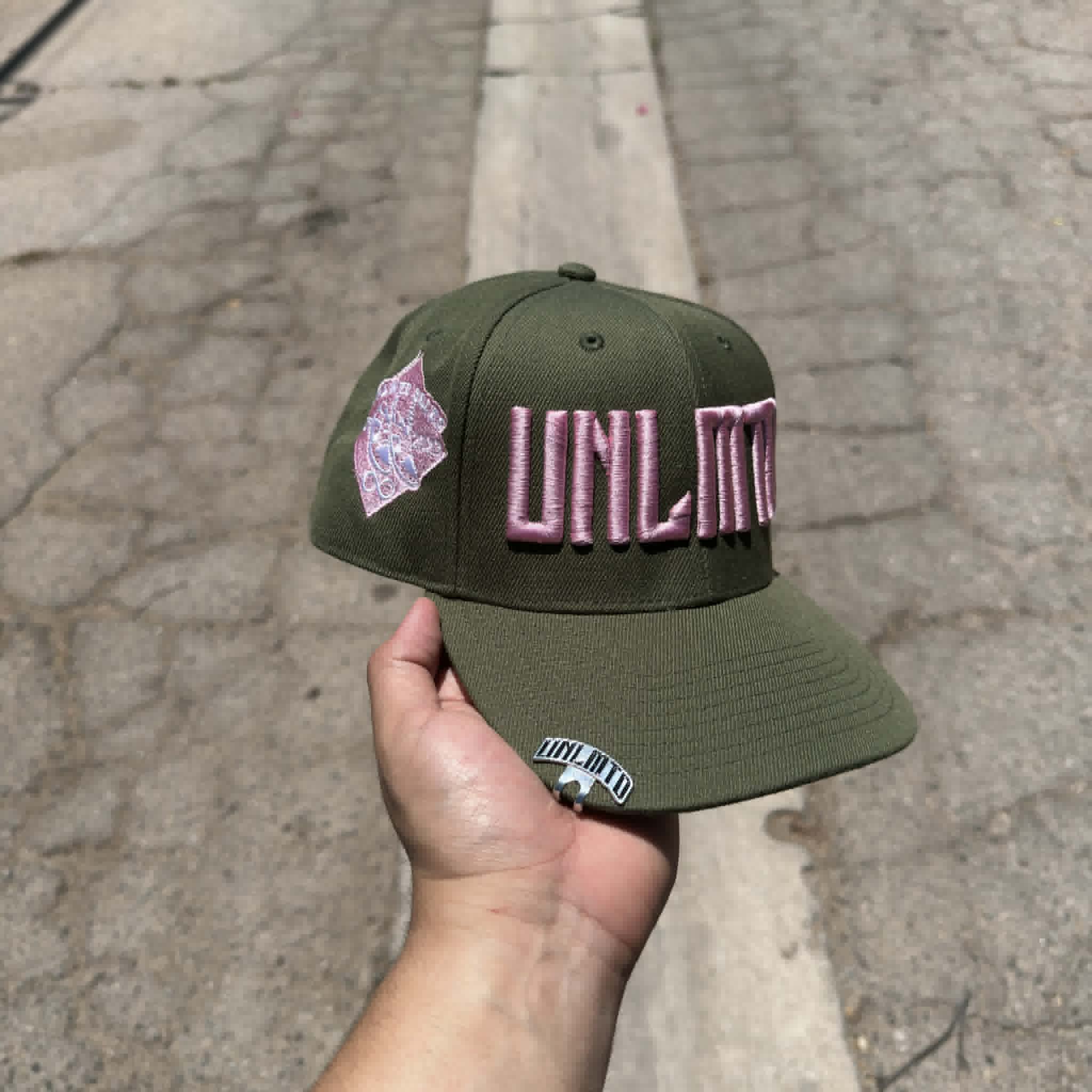 Olive green cap with pink 'UNLMTD' branding